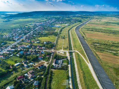 Arkasında orman olan yerleşim alanının yakınındaki baraj duvarının insansız hava aracı görüntüsü