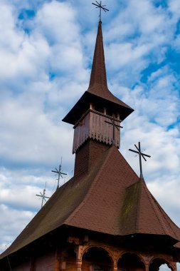 Maramures 'da bulutlu bir gökyüzünde eski ahşap bir kilise manzarası.