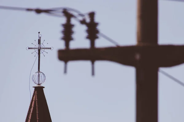 Arka Planda Elektrik Direğinin Soluk Elektrik Hattıyla Kilisenin Çatısı Kesişiyor — Stok fotoğraf