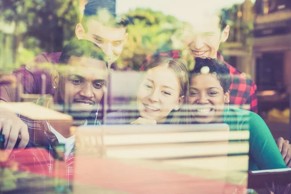 Groupe multiracial meilleurs amis utilisant ordinateur portable dans le bar restaurant urbain - Concept d'amitié s'amuser avec les nouvelles tendances et la technologie - Composition avec réflexion en verre et lomo filtre vintage — Photo