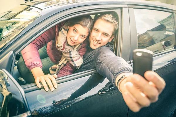 車で幸せなカップルは、電子キーを次の道路の旅 - 輸送の準備ができて表示レンタル、車ローンのコンセプトのレンタル サービス - ソフト バックライトで人々 を満足し、フィルターを desat — ストック写真