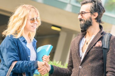 Hipster adam ve gayri resmi iş toplantısı - kavramı kentsel moda insanlar ile profesyonel müdahale - yumuşak desat filtresiyle adlı sarışın kadın el sıkışma kompozisyon eğilme ve genç kadın üzerinde odaklanmak