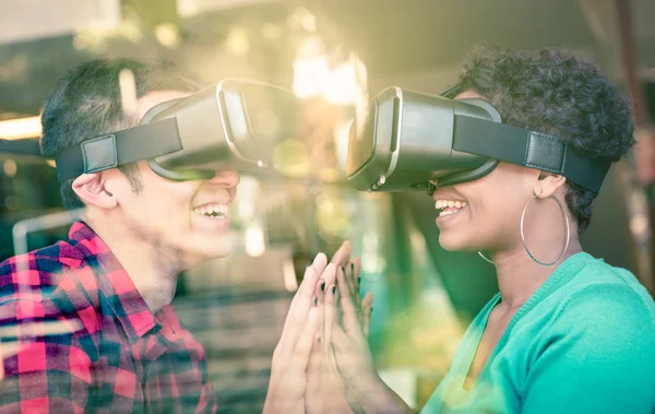 Мультирасовая пара влюбленных выходит за рамки расового разнообразия через очки виртуальной реальности - Молодые люди получают удовольствие, используя новые технологии - Состав с окном отражение на увеличенном гало вспышки солнца — стоковое фото
