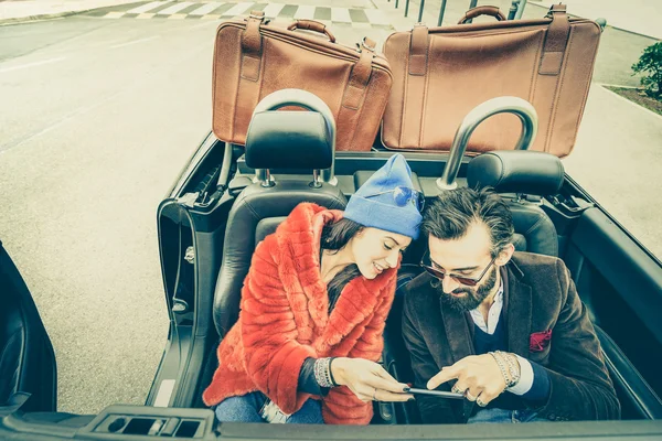 Lyckligt par att ha kul med GPS på bil resa - Hipster kille att ha kul med mode flickvän på roadtrip - kärlek relation koncept med ungdomar på turné tillsammans - mjuk retro lomo filter — Stockfoto