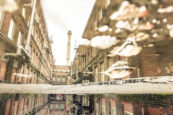 Puddle odbicie opuszczonej fabryki w dzielnicy Sankt Petersburgu w Rosji - Urban decay koncepcja z zapomnianych miejsc na świecie - Soft focus ze względu na odbicie wody - Retro desat filtr — Zdjęcie stockowe