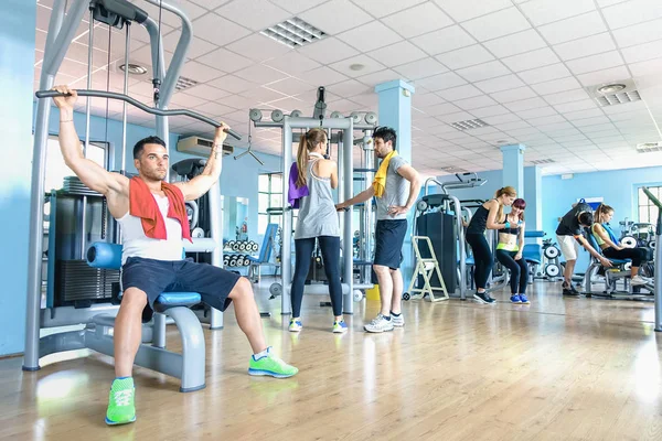 Small group of sportive friends at gym fitness club center - Happy sporty people interacting in weight room training - Social gathering concept in sport lifestyle context - Main focus in middle frame — Stock Photo, Image