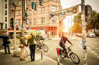 Berlin, Almanya - 7 Ekim 2016: hareket görünümü bisikletçileri ve günbatımı - kutusu Hagener Strasse Friedrichshain bölgesinde başında, yayalar ile günlük yaşamın sıcak vintage filtre vignetted