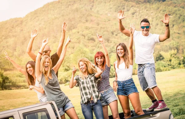 Group of happy friends having fun at countryside party ride on pick up truck car - Friendship concept with young people sharing time together on farmhouse picnic - Soft warm desaturated green filter — Stock Photo, Image