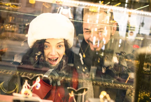 Moderne hipster paar winkelen op winter doek wijzen sieraden winkel etalage - consumentisme concept met jonge mode mensen op zoek naar kerstcadeau stedelijke stad Tour - Focus op vrouw — Stockfoto