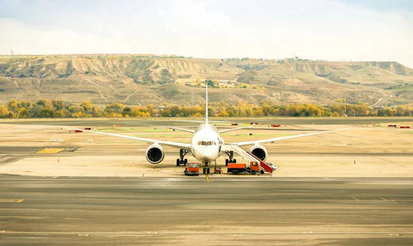 Front view of modern airplane at terminal gate ready for takeoff - International airport with soft desaturated color tones - Emotional wanderlust concept and travel around world on nostalgic filter — Stock Photo, Image