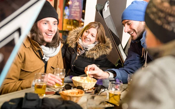 맥주를 마시는 젊은 여성에 초점을 맞춘 따뜻한 밤 필터에 칩-바 눈 장비 스키 리조트 레스토랑에서 재미 쾌활 한 사람들-우정 개념을 먹는 행복 친구 — 스톡 사진