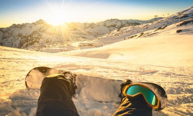 Snowboard oturan günbatımı Les Deux Alpes ski resort - kış spor kavramı kişi binmeye hazır dağın tepesinde ile - bacaklar görünümü Point şu anda sıcak aydýnlatma filtre ile rahatlayın.