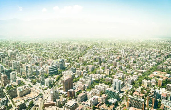 Aerial drone view of skyscrapers in downtown district of Santiago de Chile - Modern buildings and skyline in chilean biggest city with green areas and streets intersections - Warm bright color tones — Stock Photo, Image