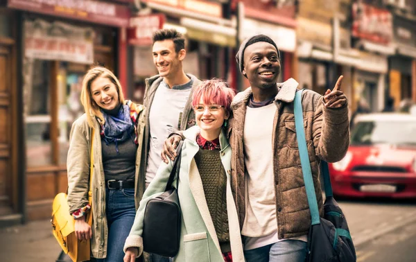 Happy multiraciale vrienden lopen op Brick Lane in Shoreditch, Londen - vriendschap concept met multiculturele jongeren over winterkleren plezier samen - Soft focus met donkere contrasterende filter — Stockfoto