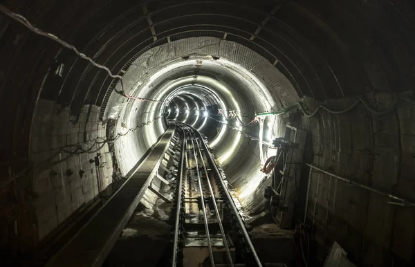 Galeria de túneis subterrâneos de minas com trilhos ferroviários de trabalho - Conceito industrial com transporte e conexão sob a terra — Fotografia de Stock