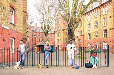 Çok ırklı insanlar grubu ve kentsel sokulgan istimal smartphone Shoreditch Londra - teknoloji bağımlılığı yaşam tarzı konsepti ile mobil akıllı telefon üzerinde sıkılmış çocuklar ve kız manifatura - sıcak retro filtre yakınındaki