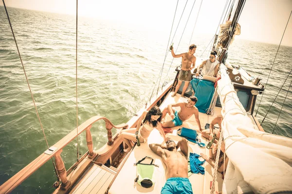 Felices amigos multirraciales divirtiéndose en la fiesta de viaje en barco de vela con dj set - Concepto de amistad con jóvenes multirraciales en velero - Estilo de vida de viaje en ubicación exclusiva - Filtro retro caliente —  Fotos de Stock