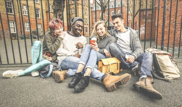 Group of happy multiracial best friends having fun using mobile smart phone - Young hipster people addicted by smartphone on social network community - Technology concept - Vivid saturated color tones — Stock Photo, Image