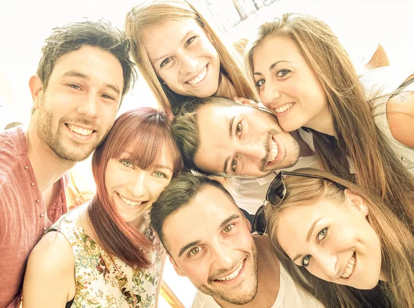 Felices mejores amigos tomando selfie al aire libre con retroiluminación primaveral - Concepto de amistad y felicidad con los jóvenes divirtiéndose juntos - Filtro vintage cálido con tonos de color brillante sol — Foto de Stock