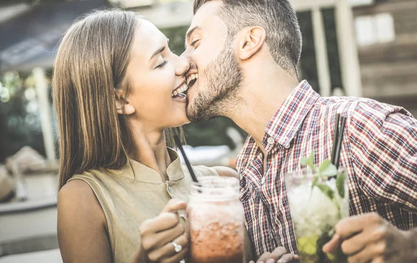 英俊的男人亲吻年轻女人在时尚鸡尾酒酒吧-快乐对情侣的爱情故事开头-醉酒的感觉概念与男朋友和女朋友在复古滤清器-重点放在脸上 — 图库照片