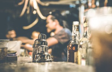 Barmen ve içme ve eğlenmek shaker üzerinde kokteyl bar - insanlarla birlikte vaktinizi sosyal toplama kavramı - sıcak retro kontrast filtre ile odak, insanlar bulanık ufuk yan görünüm