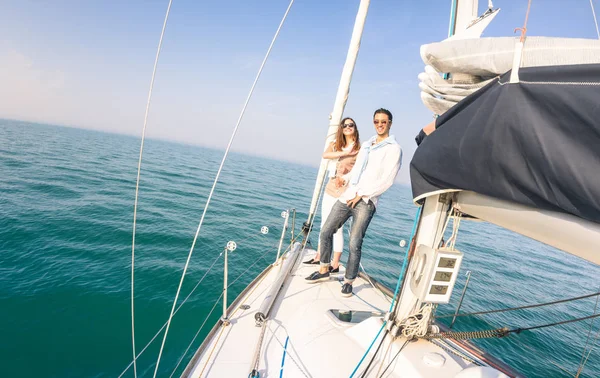 Pareja joven enamorada en velero divirtiéndose con copas de flauta de champán - Happy exclusive travel concept on sailboat tour - Boyfriend and girlfriend on luxury cruise - Sunny afternoon color tones —  Fotos de Stock