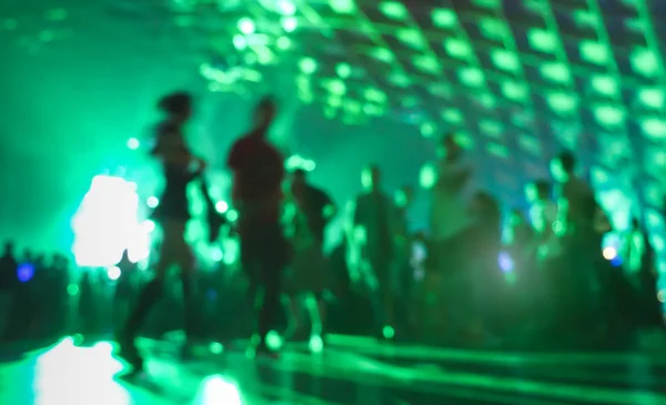 Persone offuscate astratte che vanno avanti e ballano all'evento del festival notturno di musica - Immagine sfocata della festa della discoteca con spettacolo laser - Concetto di intrattenimento notturno - Filtro verde vivido — Foto Stock