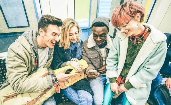 Grupo de amigos hipster multirraciales que se divierten en el tren subterráneo - Concepto de amistad urbana con los jóvenes que ven el teléfono móvil en el área subterránea de la ciudad - Filtro vintage con enfoque en la chica rubia — Foto de Stock