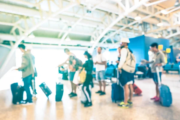 紺碧の太陽フィルター飛行機旅行 - スーツケース荷物バックパックで乗客に旅行放浪癖の概念 - の国際空港のターミナルのゲートでキューで待機してぼやけて多重人 — ストック写真