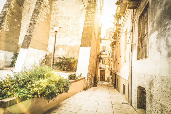 Medieval narrow street in the old city of Cagliari at sunset - World famous european city in the italian region of Sardinia - Wanderlust and travel concept on Italy destinations - Warm sunshine filter