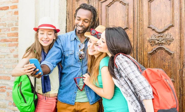 Grupo de amigos multirraciales felices tomando selfie con el teléfono inteligente móvil - Jóvenes hipster adictos por teléfono inteligente en la comunidad de redes sociales - Concepto de tecnología - Vivid saturado tono de filtro — Foto de Stock