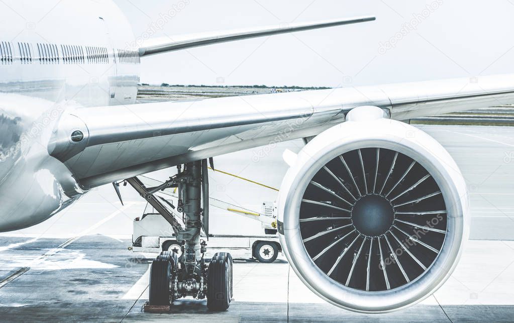 Detail of airplane engine wing at terminal gate before takeoff - Wanderlust travel concept around the world with air plane at international airport - Retro contrast filter with light blue color tones