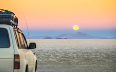 Dolunay Günbatımı ile off road jeep araç Salar De Uyuni - dünya ünlü doğa harikası yer Infinity Bolivya - Güney Amerika özel peyzaj seyahat ve Yolculuk tutkusu kavram - odak üzerinde
