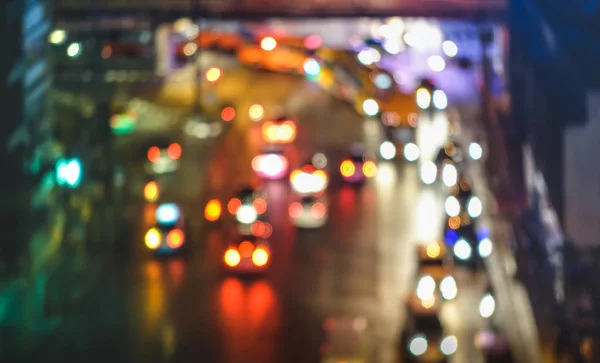 Multicolored bokeh of cars at rush hour in Bangkok city urban area - Defocused traffic jam in highway intersection - Transport concept with blurred vehicles at night - Dark vivid color tones filter — Stock Photo, Image