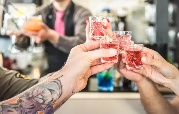 Grupa przyjaciół pijany opiekania koktajle w barze restautant - koncepcja żywności i napojów na chwile życie nocne - rozmyte barmanem serwującym napoje na tle - skupić się na ręce, doping czerwony strzał szkło — Zdjęcie stockowe