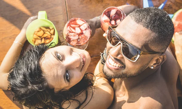 Moda homem e mulher jovem se divertindo no bar de coquetéis beber sangria - Casal multirracial feliz no início da história de amor - Conceito engraçado com namorado e namorada namoro no filtro retro quente — Fotografia de Stock