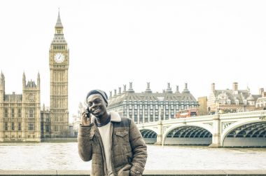 Thames riverbank London - Hipster adam erkek modeli ile modern hücre smartphone trendy moda giyim eşyası - parlak doygunluğu azaltılmış filtre, mobil akıllı telefon kullanan Afrikalı-Amerikalı genç adam