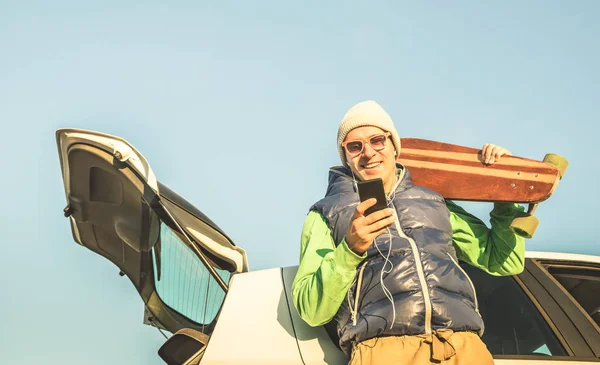 Hipster młody przystojny mężczyzna z mobile smart telefon słuchania muzyki w podróż samochodem - koncepcja nowoczesnej technologii i wanderlust travel odcień koloru Retro styl życia - jesień zima młodzieży alternatywnej mody- — Zdjęcie stockowe