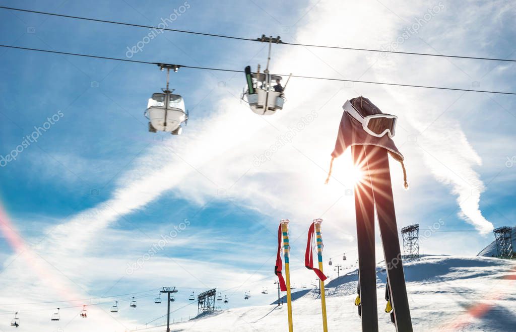 Skiing goggles and skis poles at resort glacier with chair lift on french alps - Winter vacation travel concept - High season opening on mountain slopes - Focus on sport equipment - Backlight contrast
