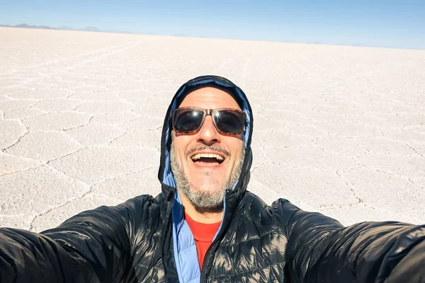 Młody człowiek solo podróżnik biorąc selfie w saltflats Salar de Uyuni w Ameryki Południowej Boliwii pustyni - przygoda wanderlust koncepcja na świat słynny natura cud w Boliwii - po południu lukrowy — Zdjęcie stockowe