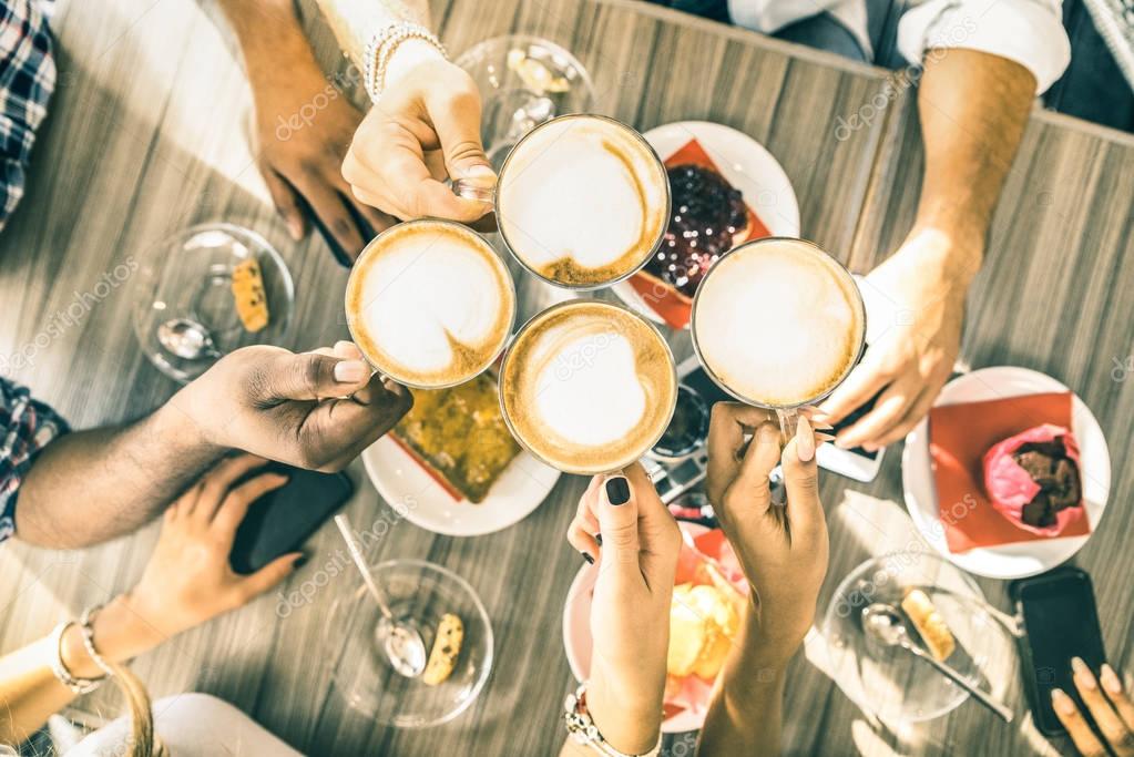 Friends group drinking cappuccino at coffee bar restaurant - People hands toasting at fashion cafeteria with upper view point - Winter drinks concept with men and women at cafe - Warm vintage filter