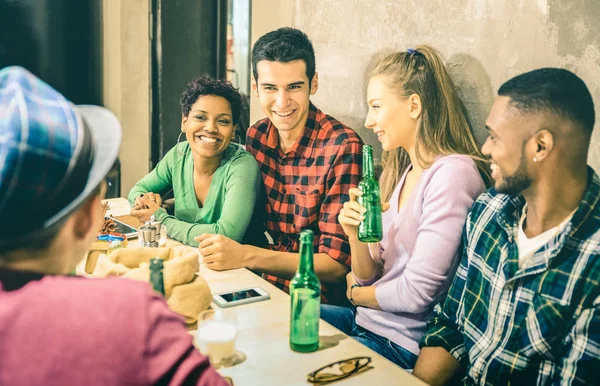 Multiracial friends group drinking beer and having fun at fashion cocktail bar restaurant - Happy friendship concept with people enjoying time talking together - Focus on african american womanhio — Stock Photo, Image