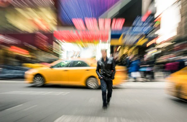 Radial blur of yellow taxicabs and unidentified person walking on 42nd street crossroad in Manhattan downtown district - Everyday commuting life New York City on rush hour in urban business area — Stock Photo, Image