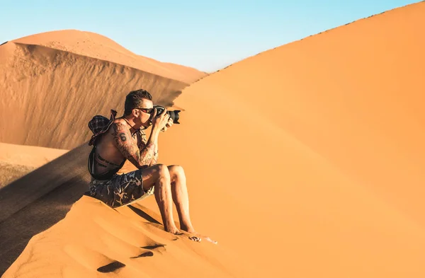 Eenzame man fotograaf zit op zand op Duin 45 in Sossusvlei - Concept van wanderlust in Namibische beroemde woestijn - avontuur reis reizen naar Afrikaanse wonderen in Namibië - zachte groenblauw en oranje filter — Stockfoto