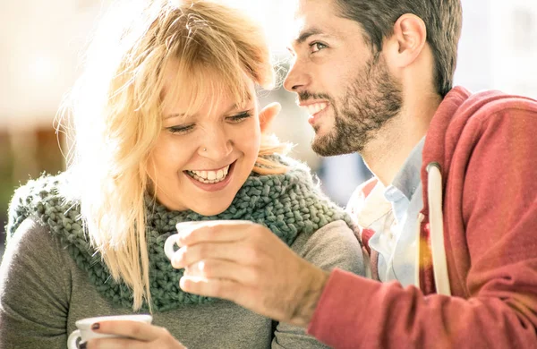 Young lovers couple at beginning of love story in coffee bar - Handsome man whispers sexy kisses in pretty woman ear - Relationship concept with boyfriend and girlfriend together - Backlight filter — Stock Photo, Image