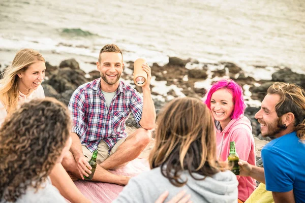 Hipster vänner att ha roligt tillsammans på stranden camping fest - flasköl vänskap resor koncept med unga resenärer dricka på havet sommarläger - fokus på killen håller stereo musikspelare — Stockfoto