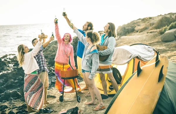 Hipster-Freunde amüsieren sich gemeinsam auf Beach-Camping-Party - Freundschaftsreise-Konzept mit jungen Leuten, die beim Sommer-Surfcamp anstoßen und Flaschenbier trinken - heller Vintage-Filter — Stockfoto