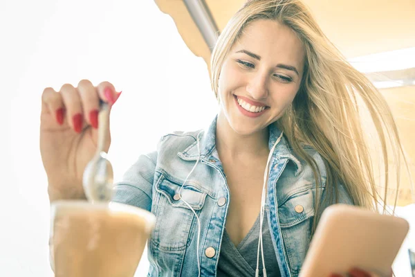 Young woman using smartphone at coffee bar - Fashion blogger girl sharing content with mobile smart phone drinking latte - Modern tourist wander lifestyle concept on social media network communication — Stock Photo, Image