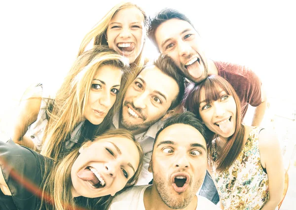 Happy beste vrienden nemen selfie buitenshuis met achtergrondverlichting - concept van de vriendschap met jonge mensen samen plezier - warme vintage filter met focus op het gezicht expressies en zachte zon halo flare — Stockfoto
