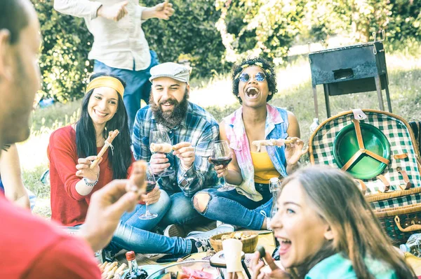 Grupp av glada vänner att ha kul utomhus hejar på bbq picknick med snacks mat dricka rött vin - unga människor njuter sommar tid tillsammans på grillparty trädgård - ungdomskoncept vänskap — Stockfoto